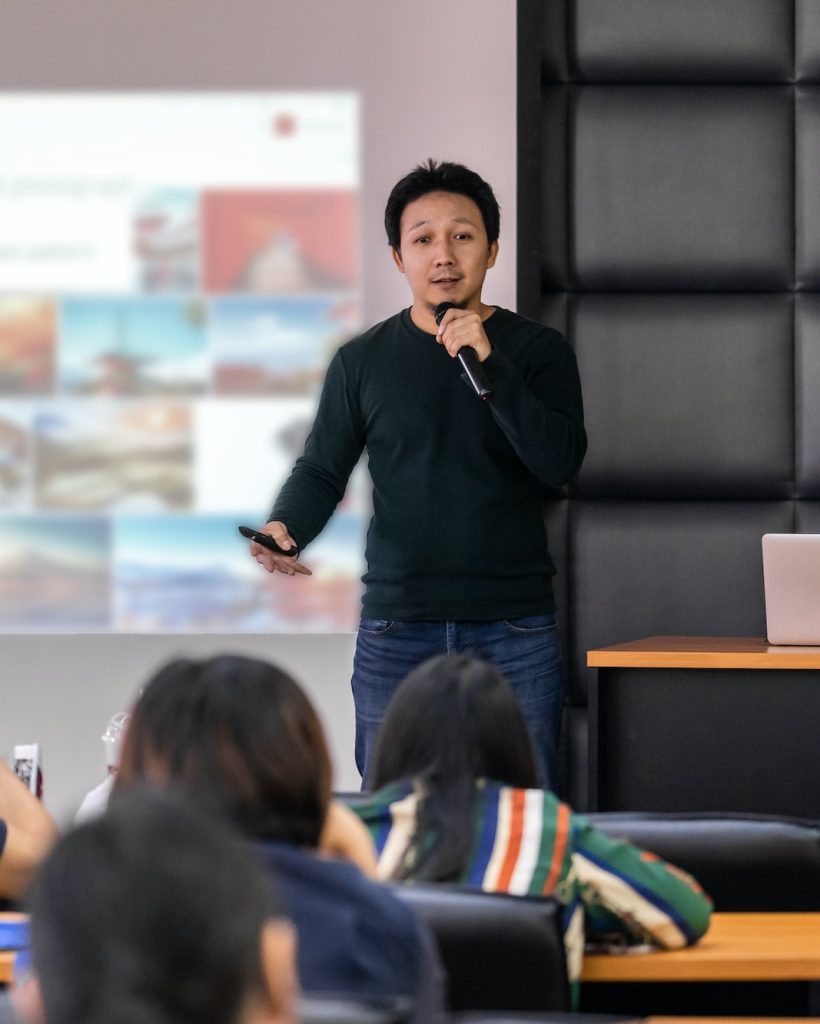 asian-speaker-or-lecture-with-casual-suit-on-the-stage-presenting-via-projector-screen.jpg